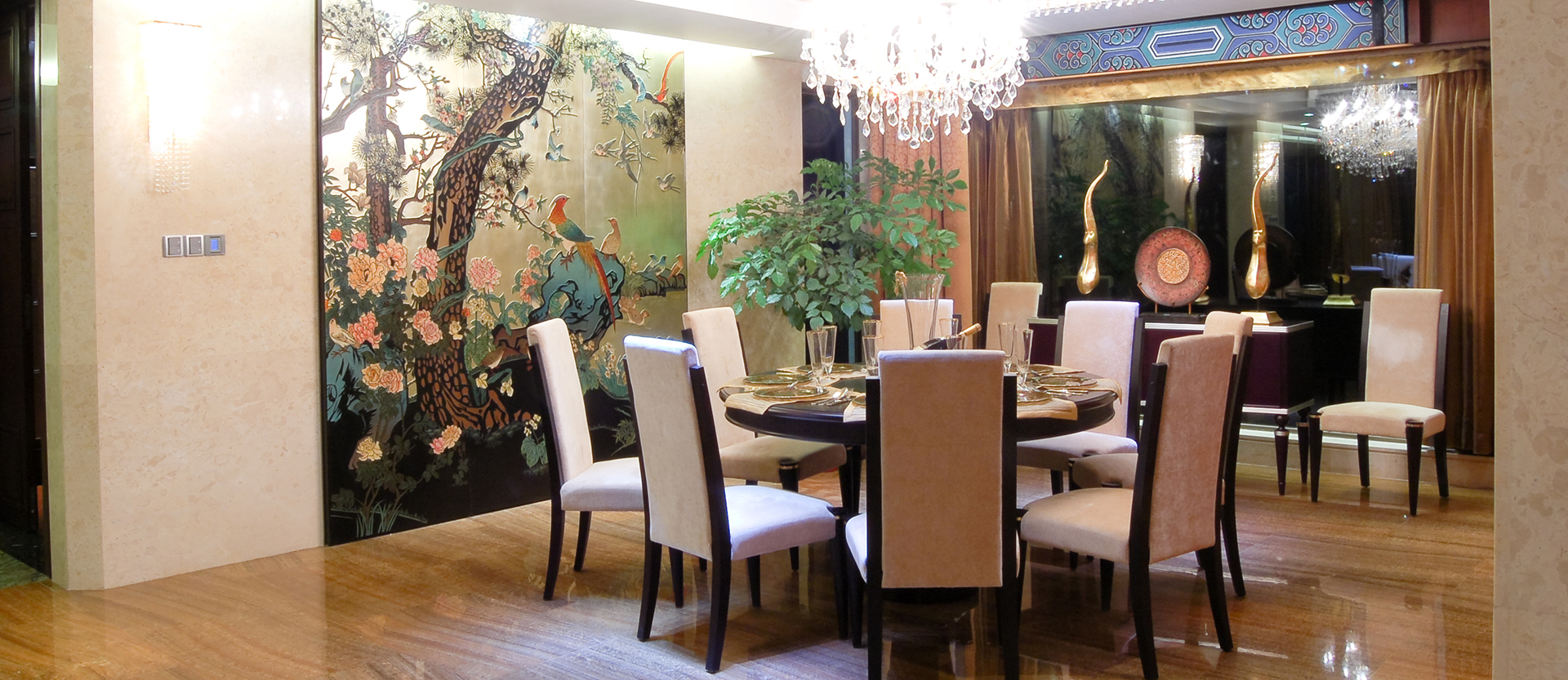 Elegant dining room with crystal chandelier featuring chinoiserie style decor.