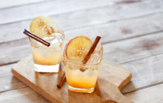 Cocktail with apple slice and cinnamon stick