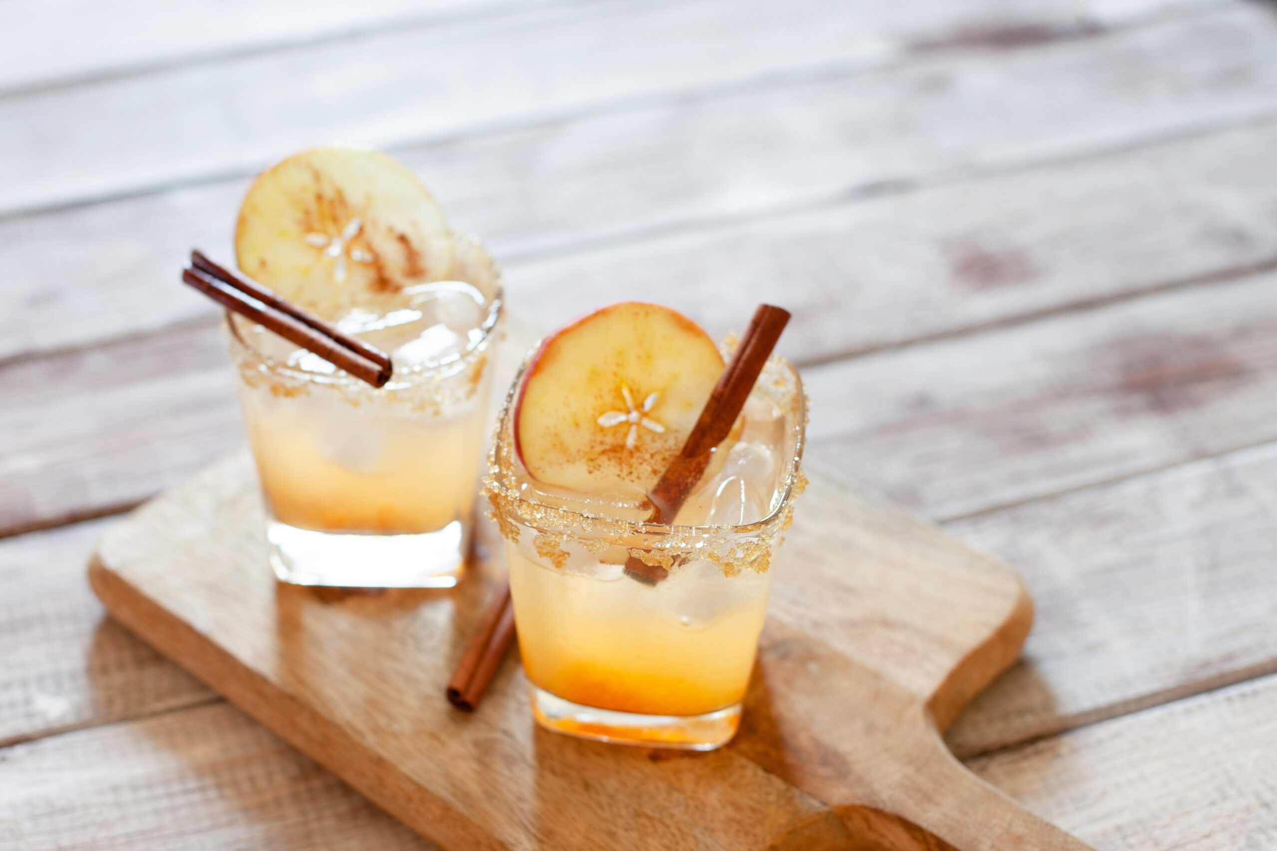 Cocktail with apple slice and cinnamon stick
